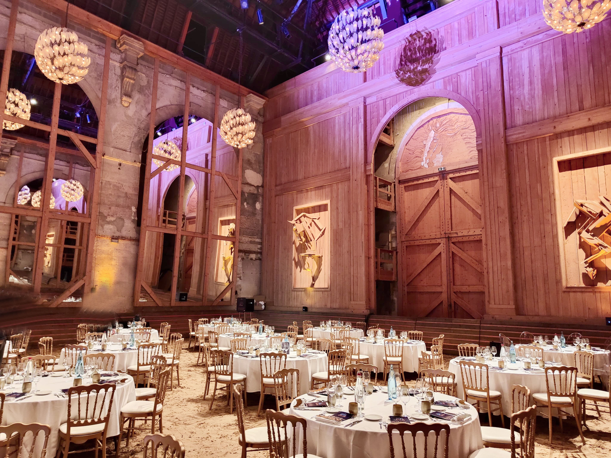 Manège de l'Académie Équestre de Versailles - format dîner de gala pour 320 personnes avec tables dressées et lumières rose