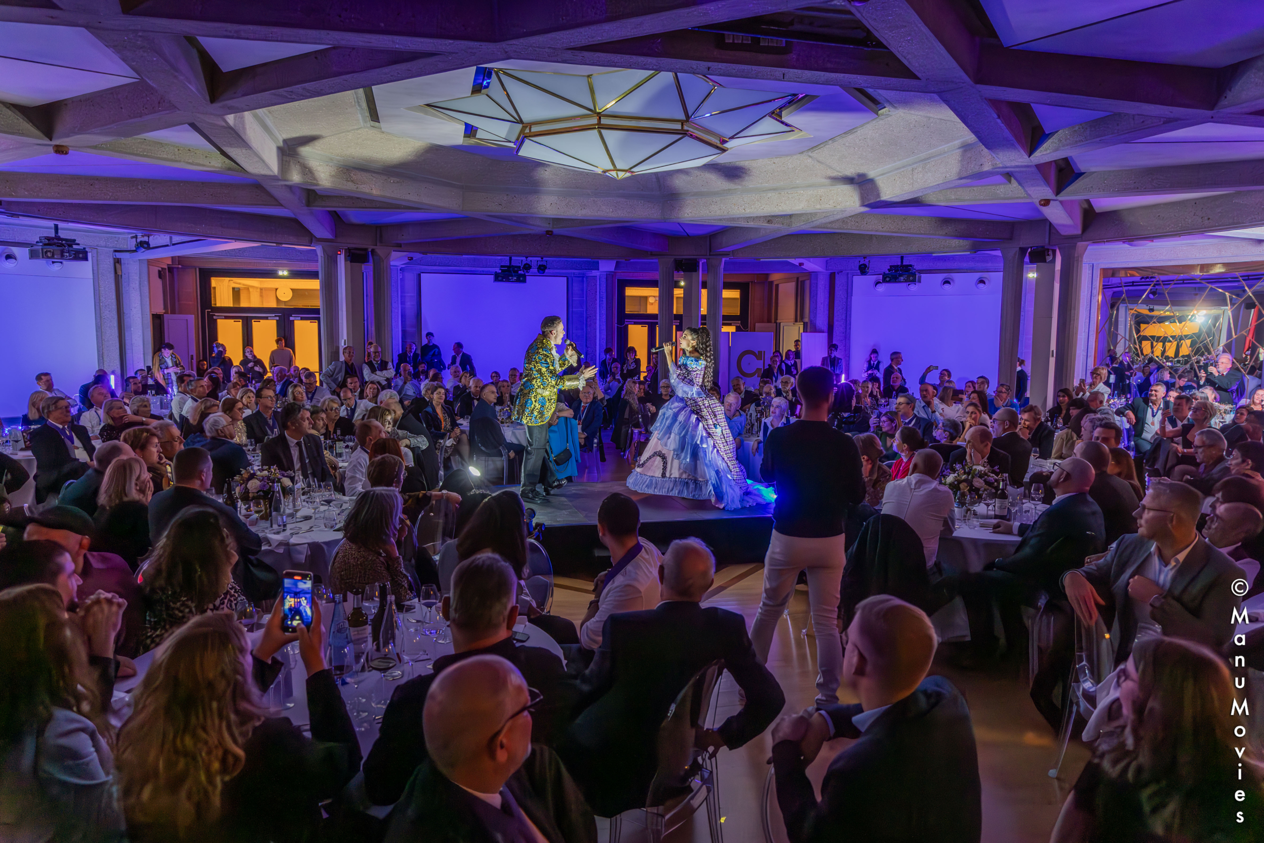 Configuration dîner assis dans le Manège – lumière tamisée et chevaux en arrière-plan