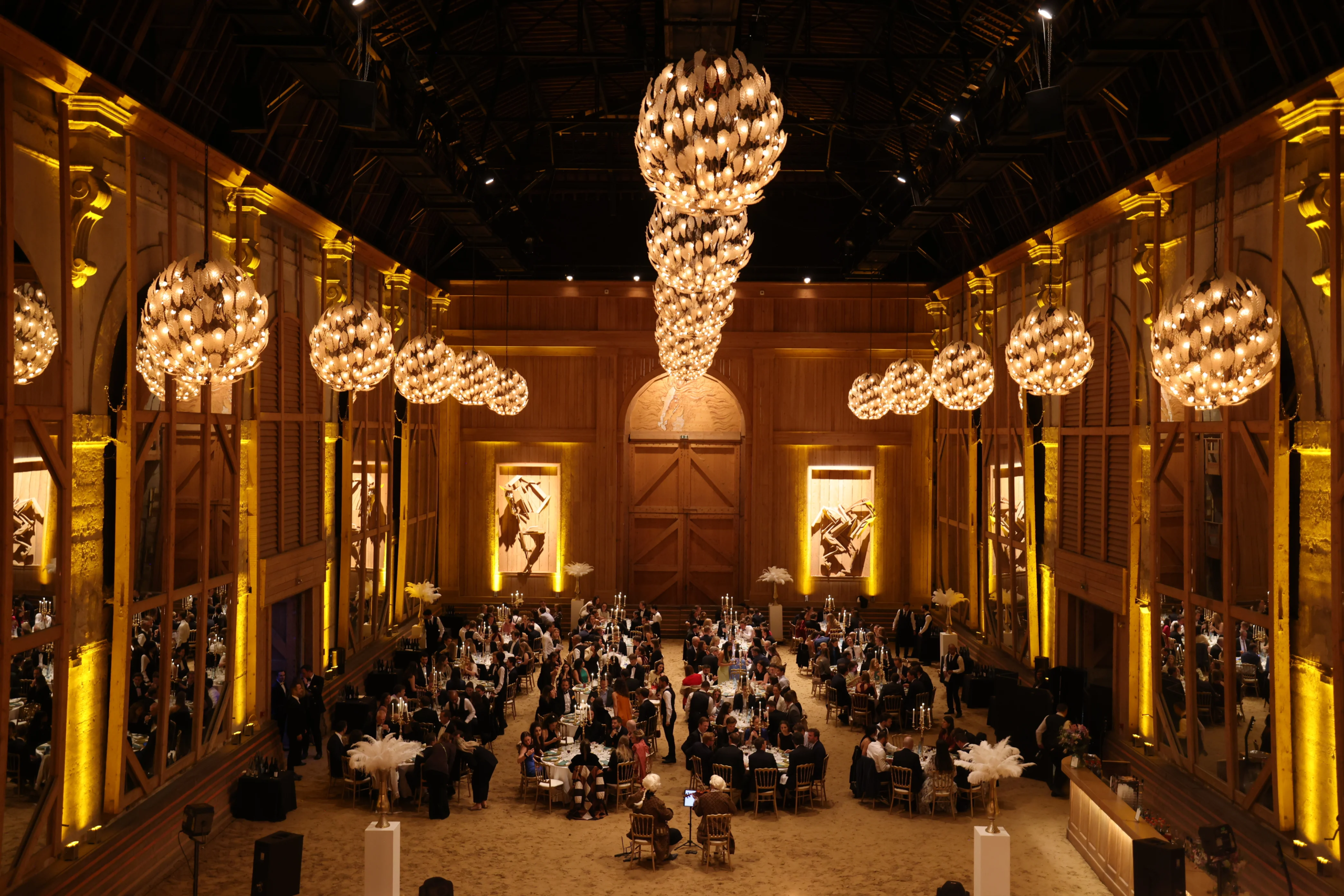 Configuration dîner assis dans le Manège – lumière tamisée et chevaux en arrière-plan